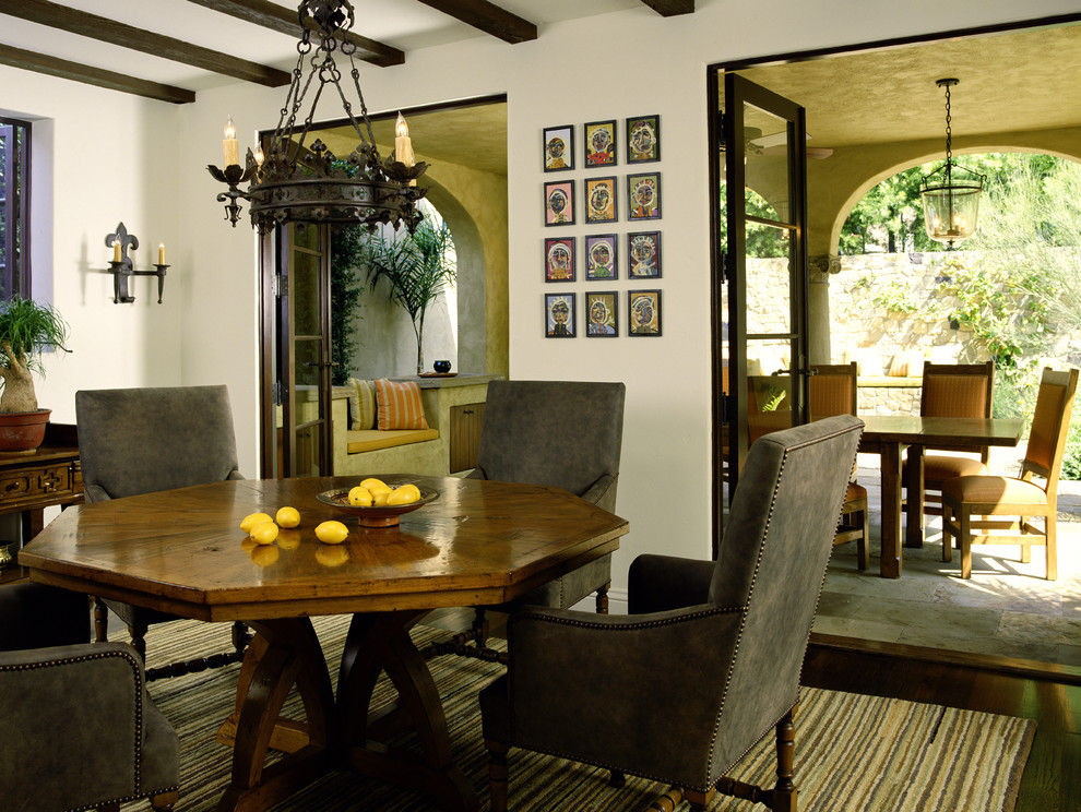 Inspiration for a mediterranean separate dining room in Los Angeles with white walls and dark hardwood floors.