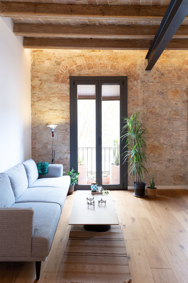 Kleines, Fernseherloses, Offenes Stilmix Wohnzimmer mit freigelegten Dachbalken und Ziegelwänden in Barcelona