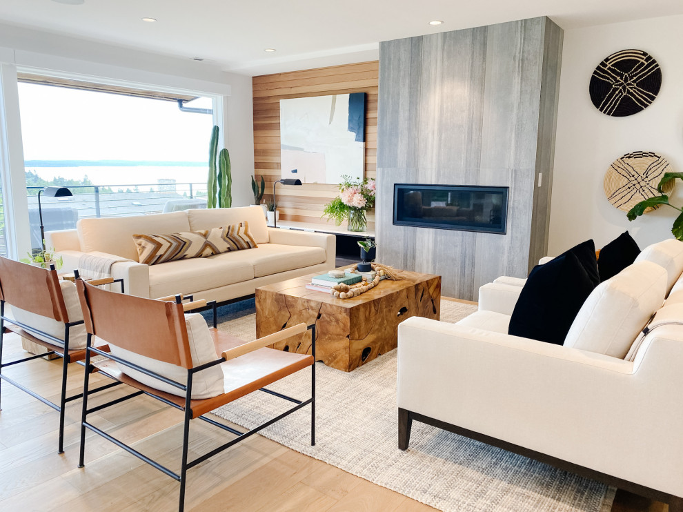 Immagine di un grande soggiorno moderno aperto con pareti bianche, parquet chiaro, cornice del camino piastrellata e pareti in legno