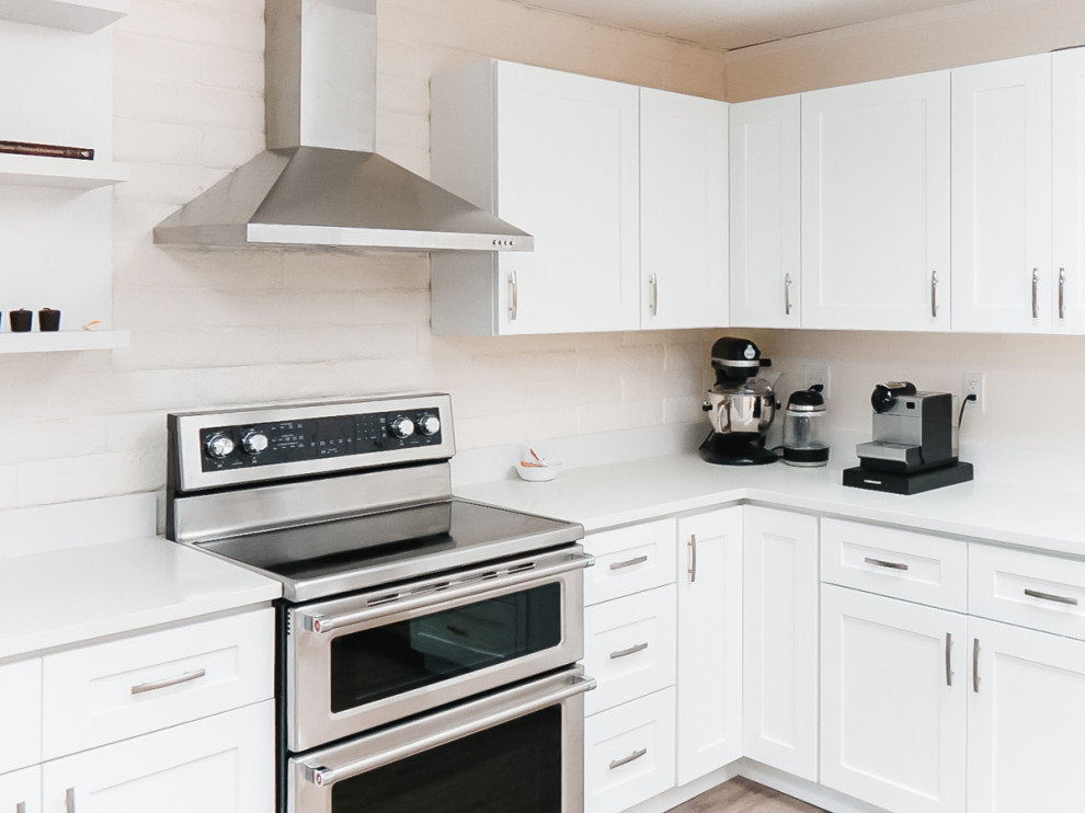 シアトルにある高級な中くらいなモダンスタイルのおしゃれなキッチン (アンダーカウンターシンク、シェーカースタイル扉のキャビネット、白いキャビネット、ラミネートカウンター、白いキッチンパネル、石スラブのキッチンパネル、シルバーの調理設備、クッションフロア、茶色い床、白いキッチンカウンター、塗装板張りの天井) の写真