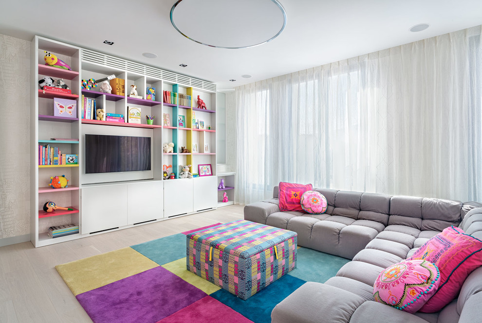 Contemporary kids' playroom in Other with white walls and light hardwood floors for girls.