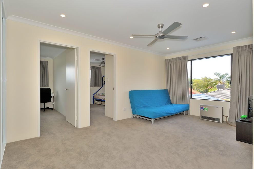 Photo of a mid-sized contemporary gender-neutral kids' room in Perth with beige walls, carpet and grey floor.