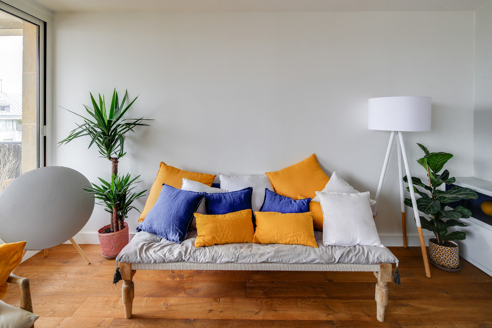 Aménagement d'un grand salon contemporain ouvert avec une bibliothèque ou un coin lecture, un mur gris, un sol en bois brun, aucune cheminée, un sol marron et aucun téléviseur.