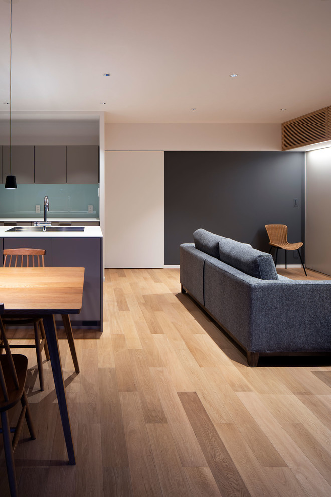 Photo of a small contemporary open concept living room in Osaka with grey walls, plywood floors, no fireplace, a freestanding tv and beige floor.