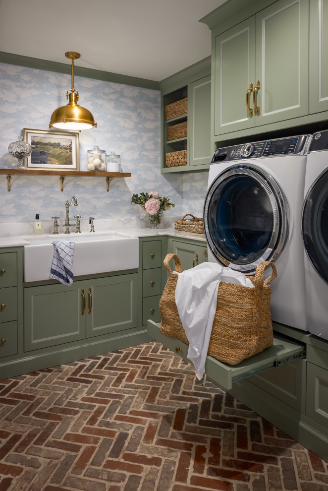 Immagine di una sala lavanderia chic con lavello stile country, ante con riquadro incassato, ante verdi, pareti blu, pavimento in mattoni, lavatrice e asciugatrice affiancate, pavimento rosso, top bianco e carta da parati