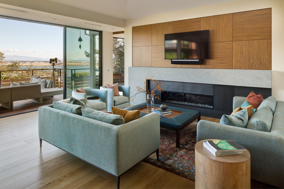 Photo of a contemporary open concept family room in San Diego with light hardwood floors and a wall-mounted tv.