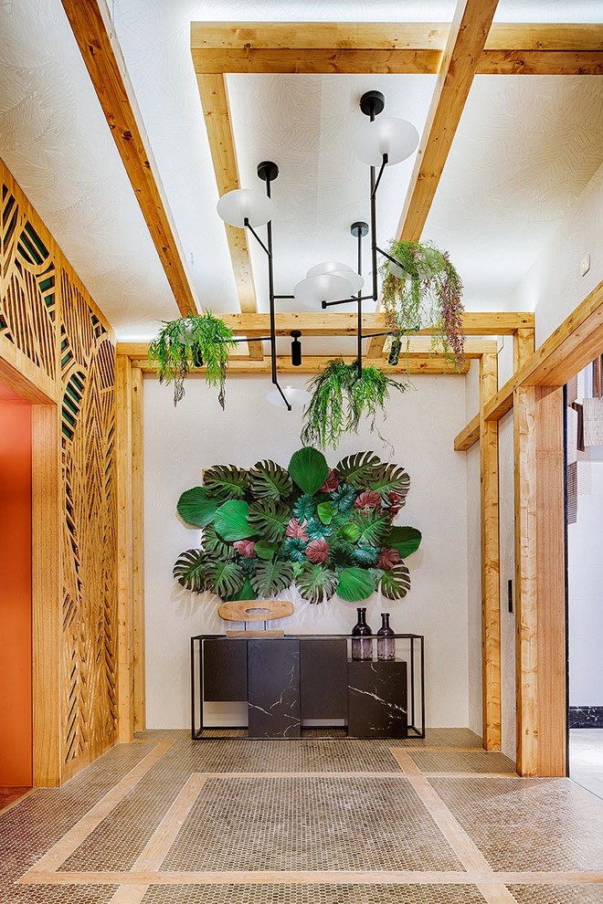 Inspiration for a large tropical vestibule in Madrid with white walls and a light wood front door.