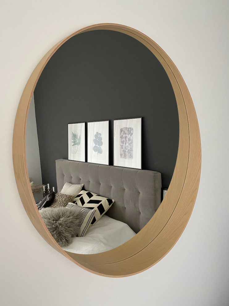 Ejemplo de dormitorio principal y gris y blanco escandinavo de tamaño medio sin chimenea con paredes grises, suelo de madera en tonos medios y suelo marrón