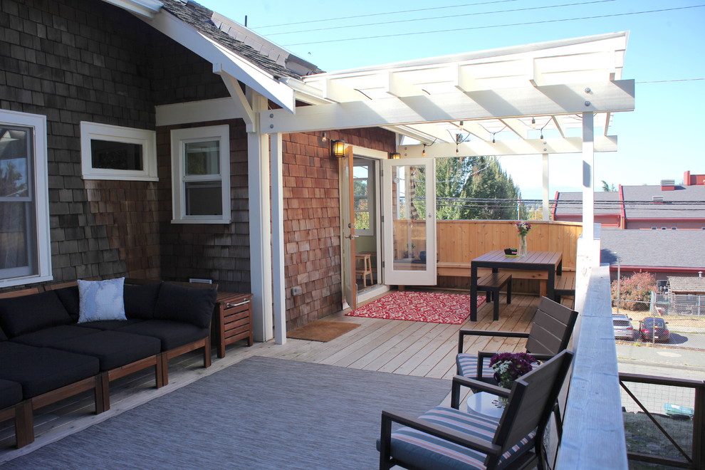 Mid-sized arts and crafts backyard deck photo in Seattle with a pergola