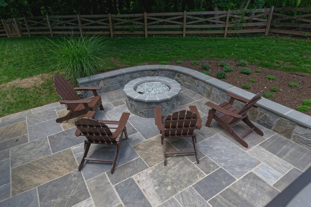 This is an example of a mid-sized traditional backyard patio in DC Metro with a fire feature and natural stone pavers.