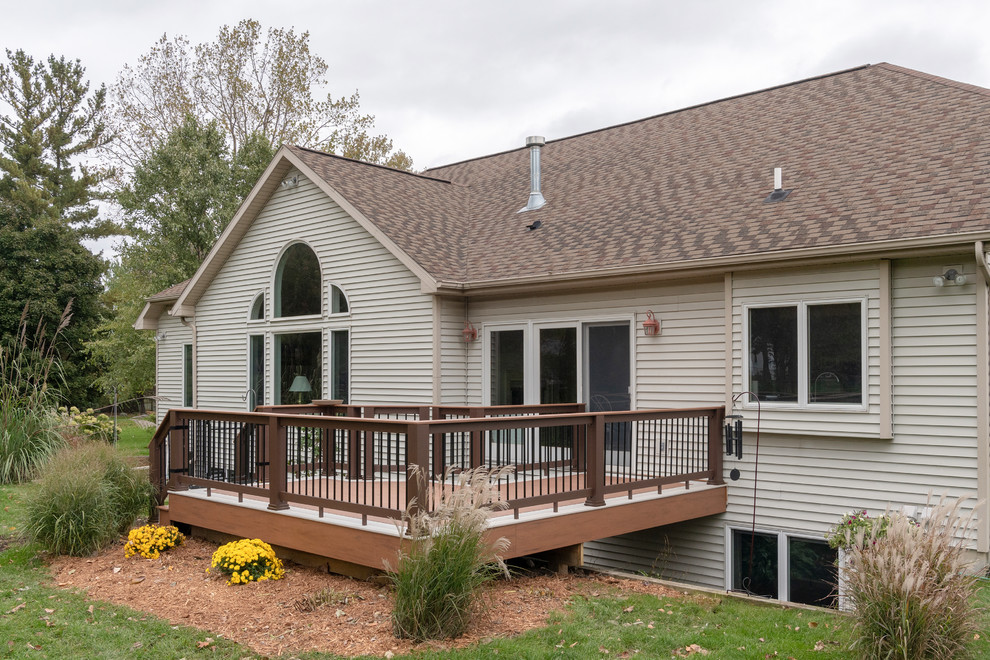 Example of a mid-sized transitional backyard deck design with no cover