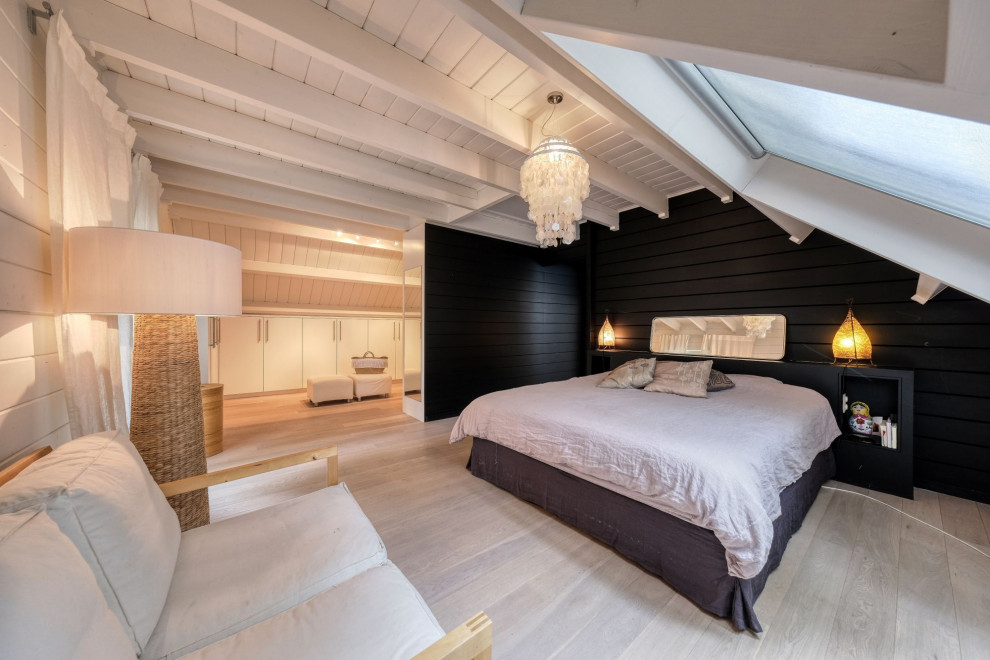 Design ideas for a large scandinavian master bedroom in Brussels with light hardwood floors and wood walls.