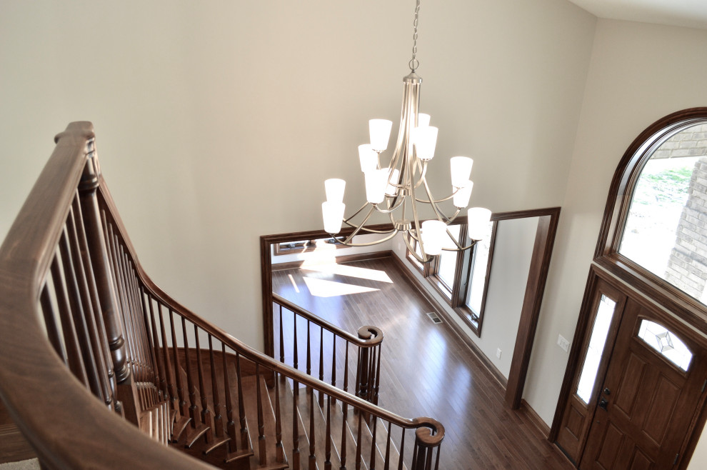 Example of a mid-sized transitional medium tone wood floor and brown floor foyer design with gray walls and a brown front door