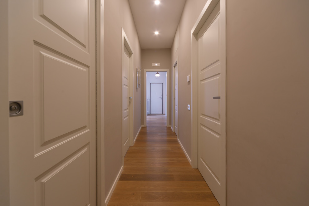 Photo of a mid-sized contemporary hallway in Rome with beige walls and light hardwood floors.