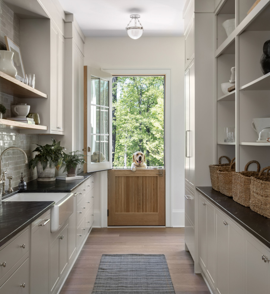 Photo of a medium sized classic galley kitchen pantry in DC Metro with beige cabinets, beige splashback, stainless steel appliances, light hardwood flooring and brown floors.