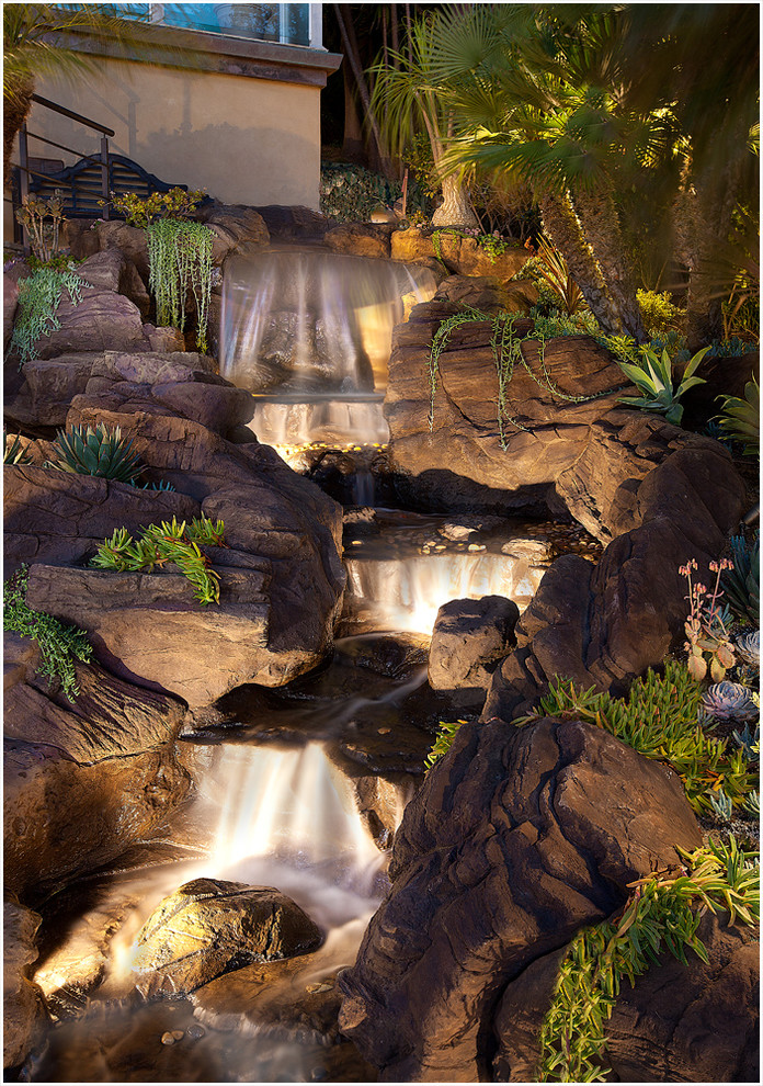 This is an example of a tropical garden in Los Angeles with a water feature.