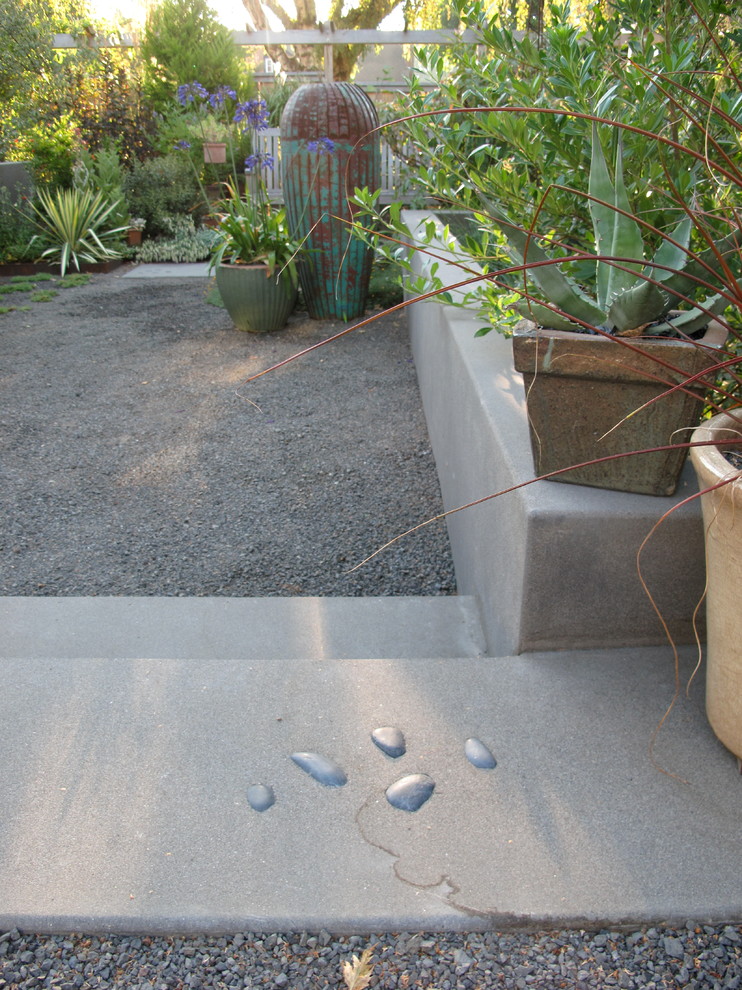 Design ideas for a mid-sized eclectic front yard garden in Portland with a retaining wall and gravel.