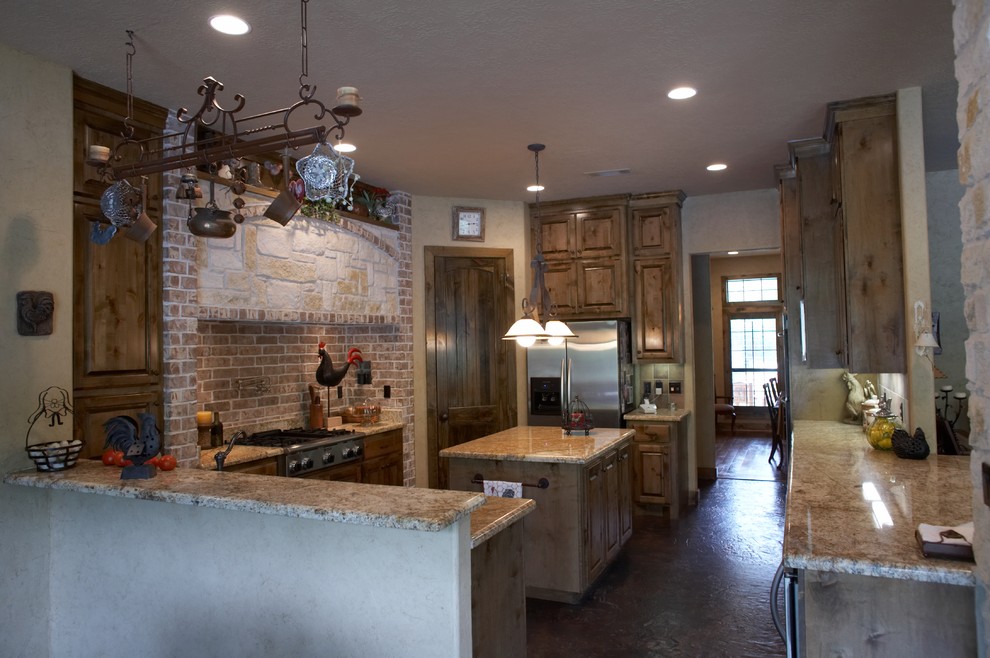 Inspiration for a mid-sized country u-shaped separate kitchen in Houston with a farmhouse sink, raised-panel cabinets, medium wood cabinets, granite benchtops, red splashback, subway tile splashback, stainless steel appliances, concrete floors and with island.