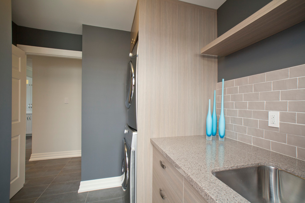 Inspiration for a transitional laundry room in Toronto with a stacked washer and dryer.