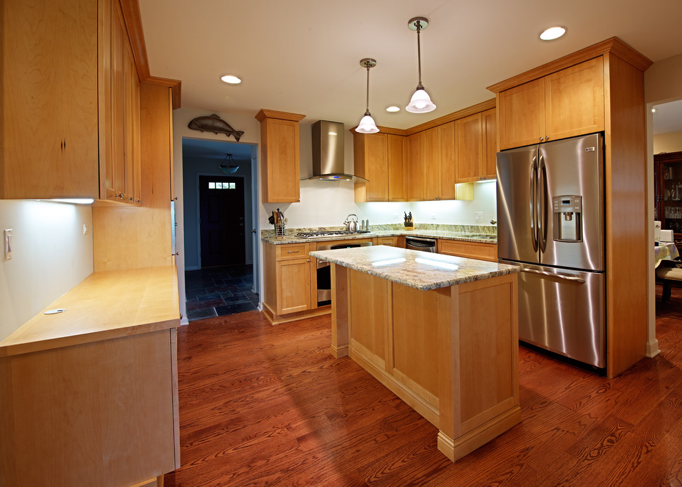 Small transitional medium tone wood floor enclosed kitchen photo in Chicago with an undermount sink, recessed-panel cabinets, light wood cabinets, granite countertops, white backsplash, stainless steel appliances and an island