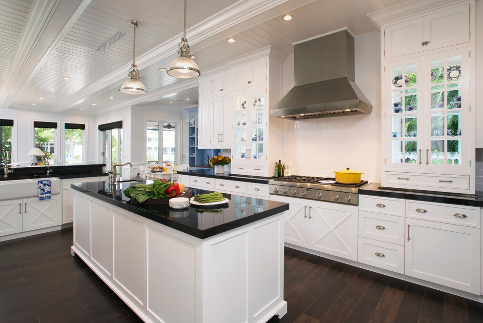 Mid-sized transitional u-shaped eat-in kitchen in Miami with a farmhouse sink, shaker cabinets, white cabinets, white splashback, stainless steel appliances, dark hardwood floors and with island.