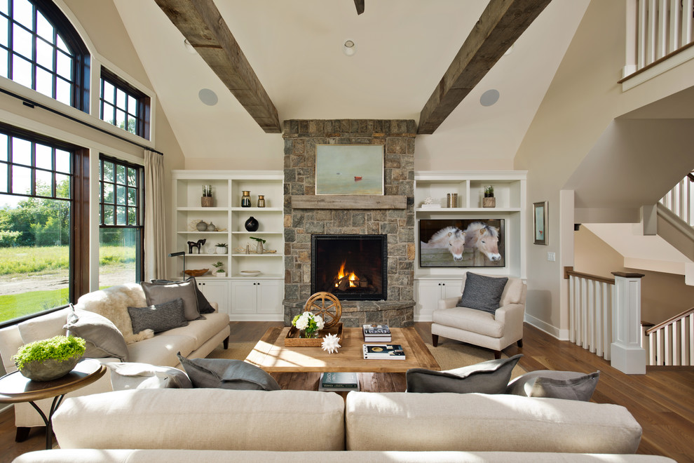Large country open concept family room in New York with a standard fireplace, a stone fireplace surround, beige walls, medium hardwood floors and a built-in media wall.
