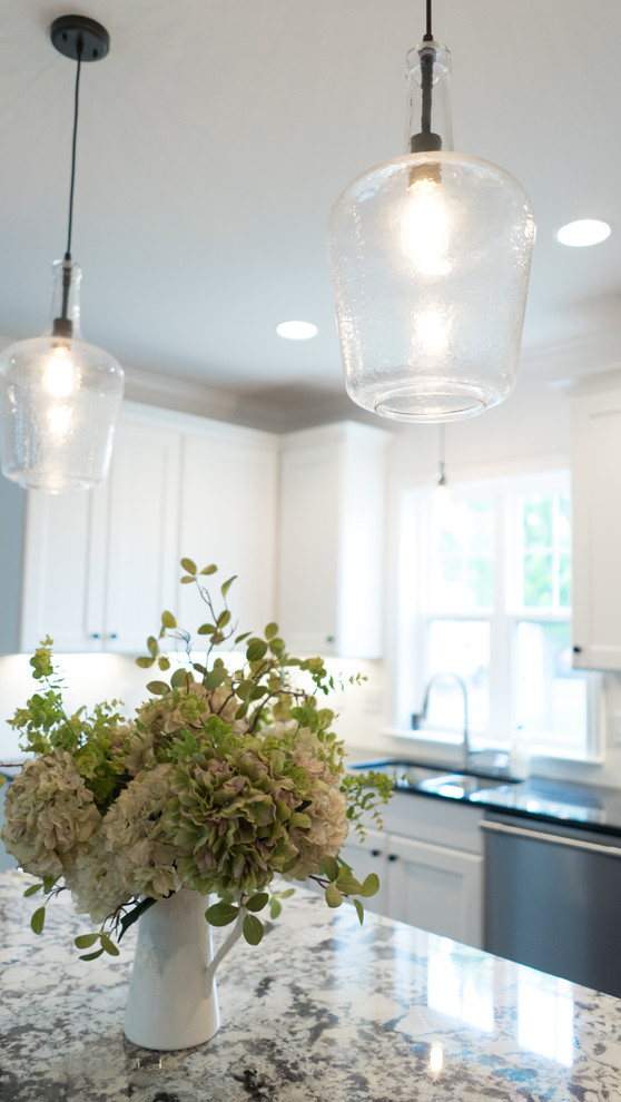 Mid-sized transitional l-shaped dark wood floor open concept kitchen photo with an undermount sink, shaker cabinets, white cabinets, granite countertops, gray backsplash, stainless steel appliances and an island