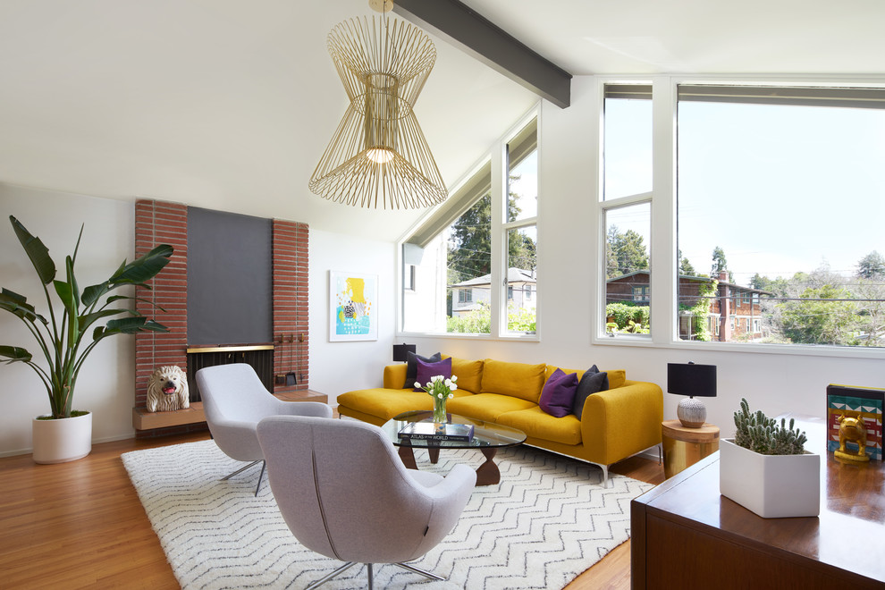 Design ideas for a large midcentury formal open concept living room in San Francisco with white walls, a standard fireplace, a brick fireplace surround, light hardwood floors, no tv and beige floor.