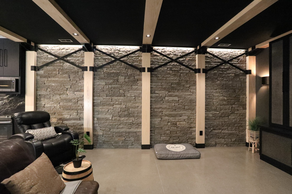 Ejemplo de sótano industrial grande con paredes negras, suelo de cemento y suelo gris