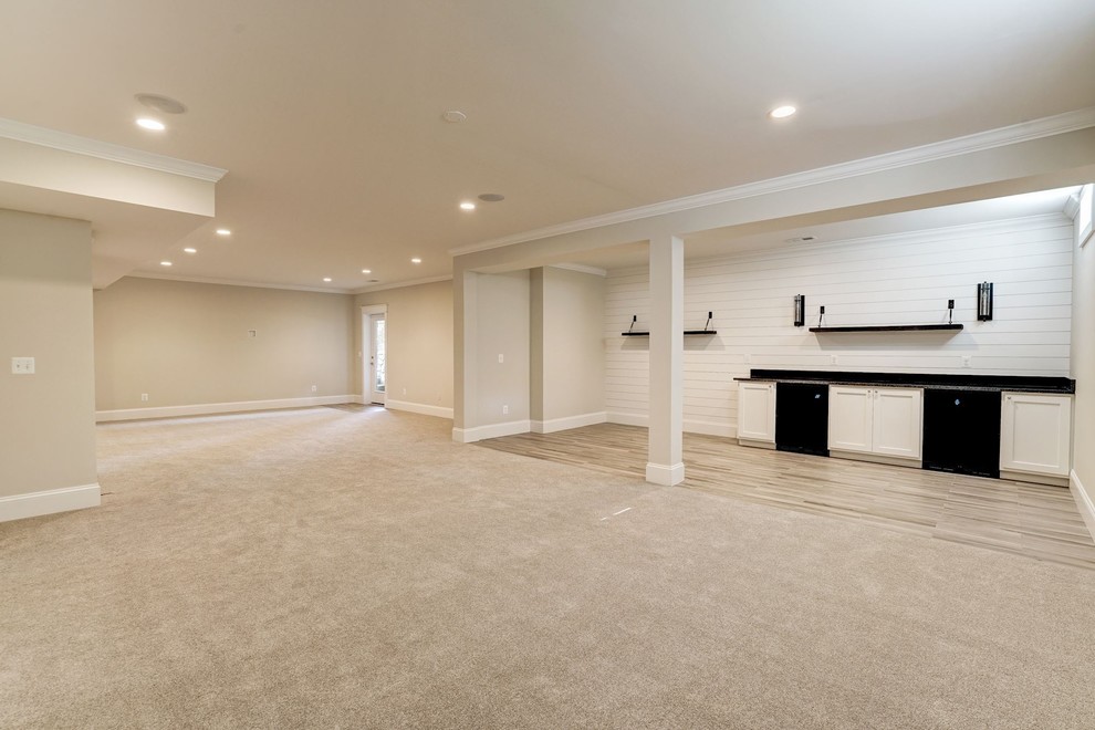This is an example of a large country walk-out basement in DC Metro with beige walls, carpet, no fireplace and brown floor.