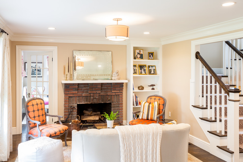 Small traditional living room in Boston with brown walls, dark hardwood floors, a standard fireplace and a brick fireplace surround.