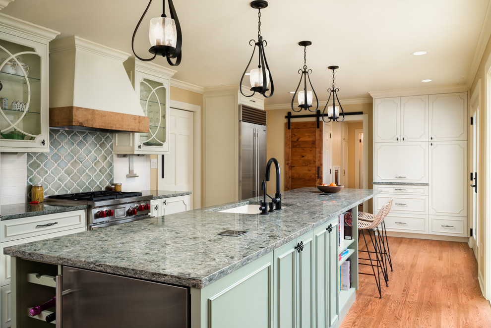 Inspiration for a traditional galley kitchen in Columbus with white cabinets, stainless steel appliances and with island.