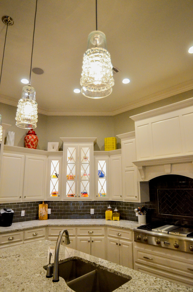 Inspiration for a large transitional u-shaped dark wood floor open concept kitchen remodel with a double-bowl sink, raised-panel cabinets, white cabinets, granite countertops, gray backsplash, stainless steel appliances and an island