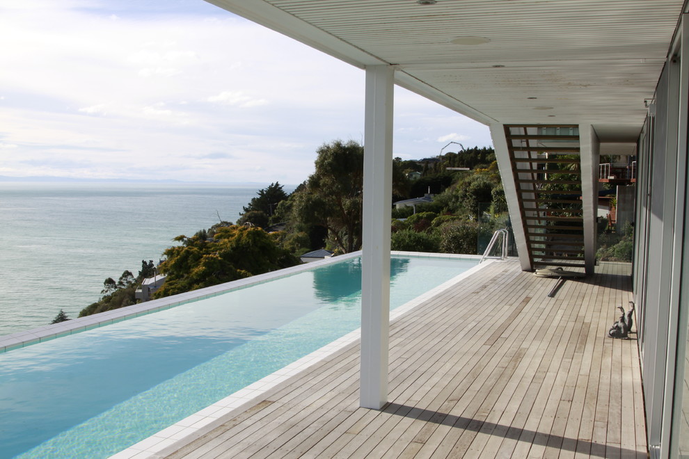 Photo of a large contemporary deck in Christchurch with a water feature and a roof extension.