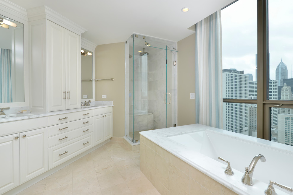 Photo of a large transitional bathroom in Chicago with an undermount sink, raised-panel cabinets, white cabinets, marble benchtops, an undermount tub, a two-piece toilet, white tile, stone tile, beige walls, marble floors and with a sauna.