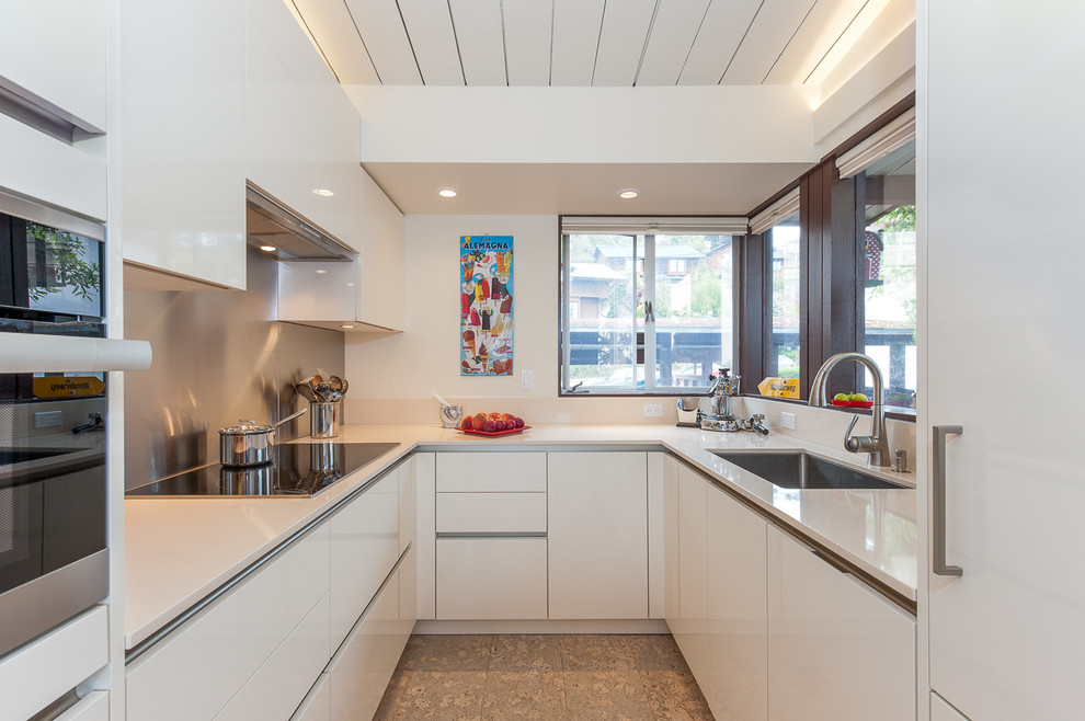 Design ideas for a small contemporary u-shaped separate kitchen in San Francisco with an undermount sink, flat-panel cabinets, white cabinets, metallic splashback, metal splashback, panelled appliances, no island and quartz benchtops.