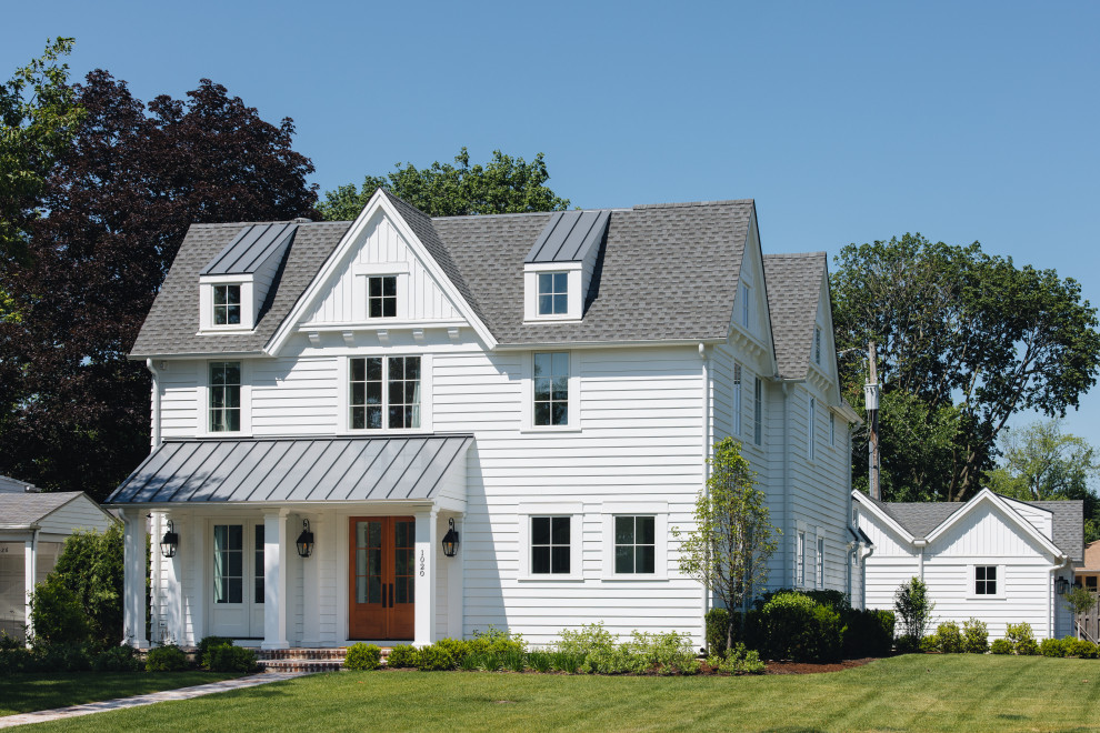 This is an example of a mid-sized country two-storey white house exterior in Chicago with a gable roof, a shingle roof, a grey roof and shingle siding.