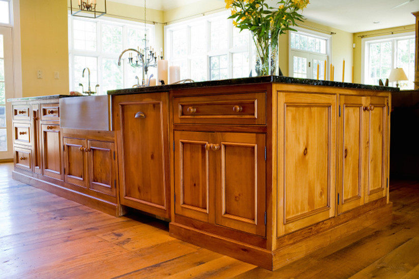 Mountain style medium tone wood floor and brown floor open concept kitchen photo in Philadelphia with a farmhouse sink, beaded inset cabinets, medium tone wood cabinets, granite countertops and an island