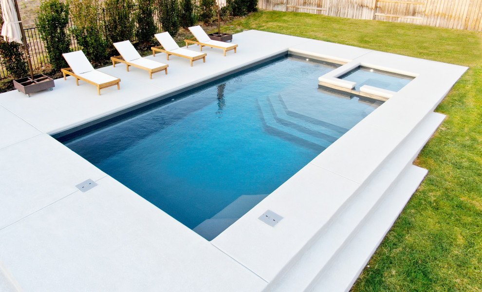 На фото: естественный, прямоугольный бассейн среднего размера на заднем дворе в стиле модернизм с покрытием из бетонных плит с