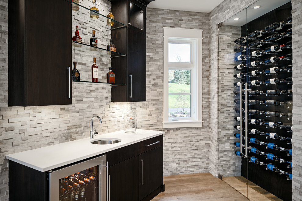 Inspiration for a mid-sized transitional wine cellar in Grand Rapids with light hardwood floors and display racks.