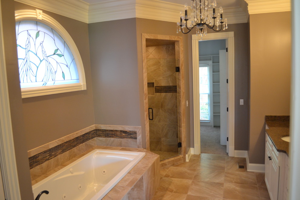 Photo of a large traditional master bathroom in Other with raised-panel cabinets, white cabinets, a drop-in tub, an alcove shower, beige tile, ceramic tile, beige walls, ceramic floors, an undermount sink and granite benchtops.
