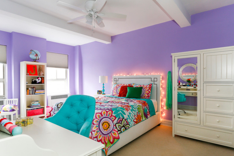 Photo of a large modern kids' room for girls in New York with purple walls and carpet.