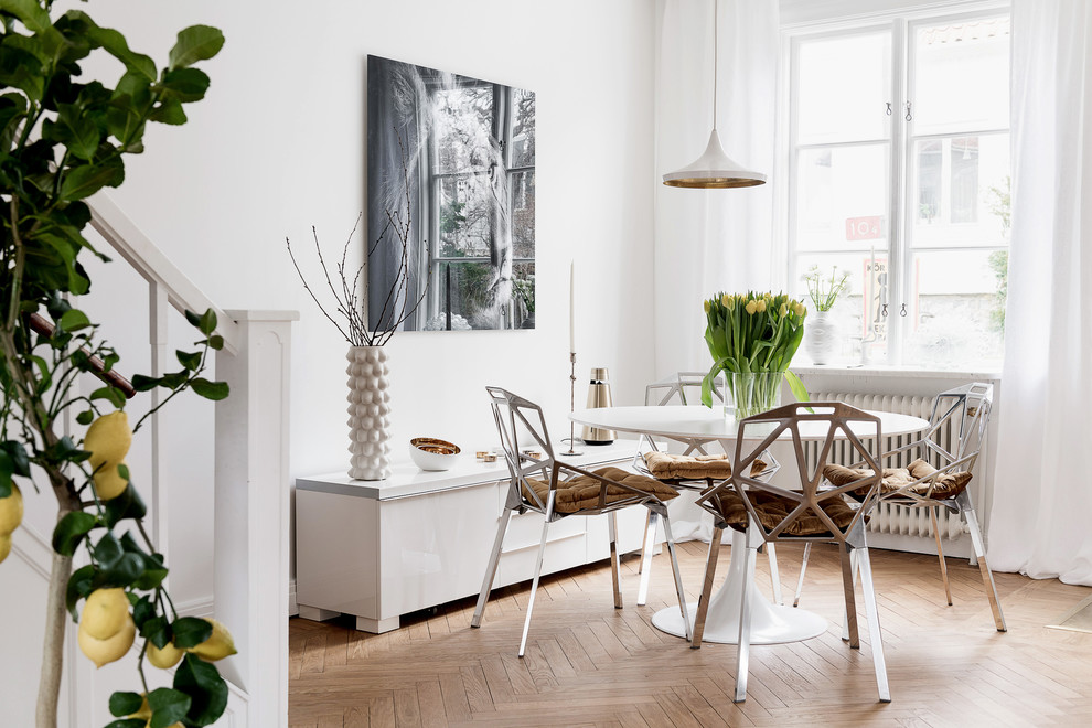 Design ideas for a mid-sized scandinavian open plan dining in Gothenburg with white walls and medium hardwood floors.