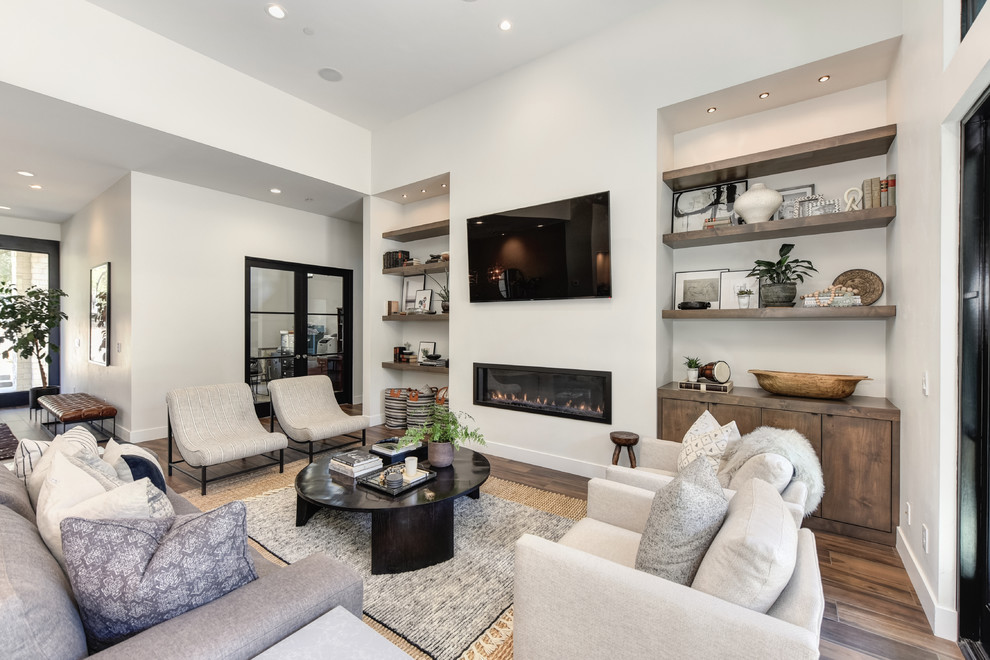 This is an example of a large contemporary formal open concept living room in Sacramento with blue walls, a ribbon fireplace, brown floor, a wall-mounted tv, medium hardwood floors and a plaster fireplace surround.