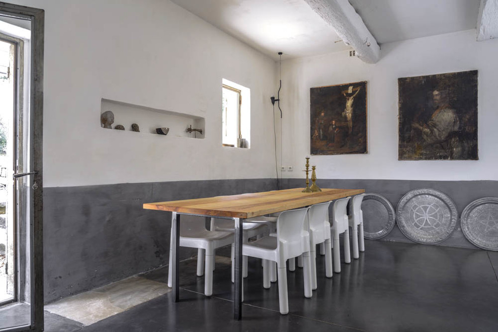 Immagine di una grande sala da pranzo mediterranea chiusa con pavimento in cemento, pareti multicolore e nessun camino