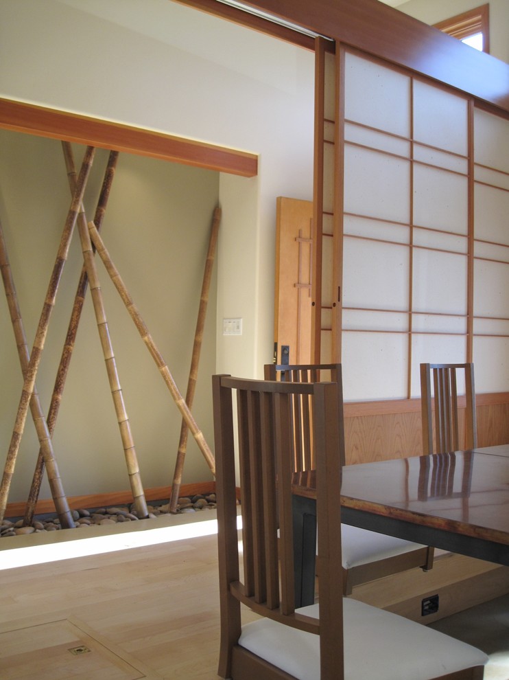 This is an example of a small asian entry hall in San Francisco with beige walls, concrete floors, a single front door and a light wood front door.