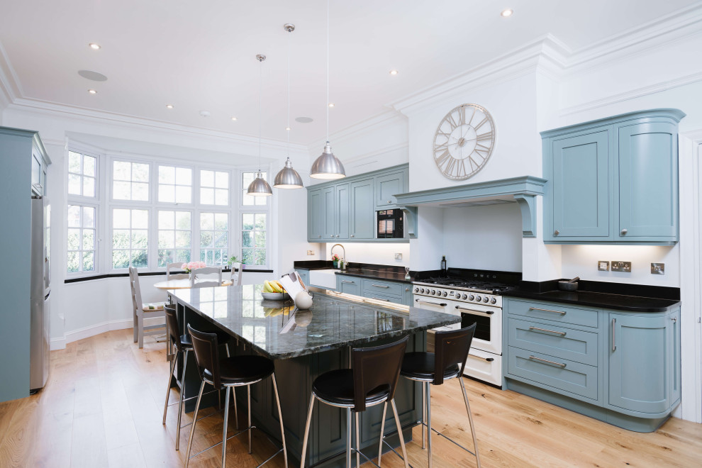 Foto på ett stort vintage flerfärgad linjärt kök och matrum, med en rustik diskho, skåp i shakerstil, blå skåp, marmorbänkskiva, vitt stänkskydd, rostfria vitvaror, mellanmörkt trägolv, en köksö och brunt golv