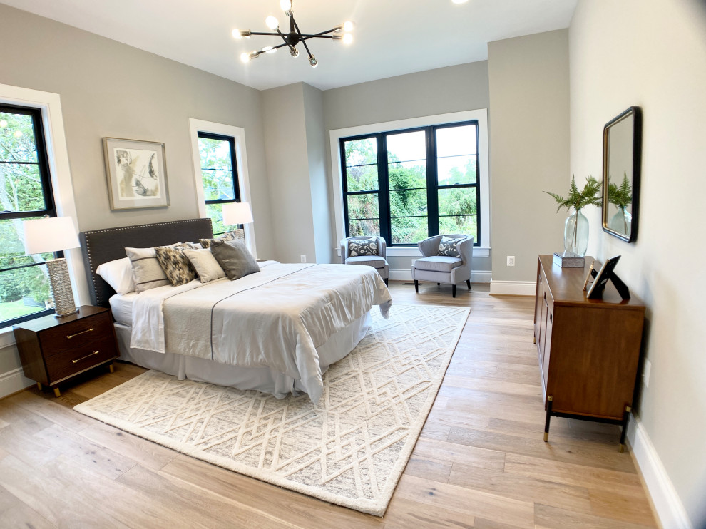 Foto de habitación de invitados de estilo de casa de campo grande sin chimenea con paredes grises, suelo de madera clara y suelo beige