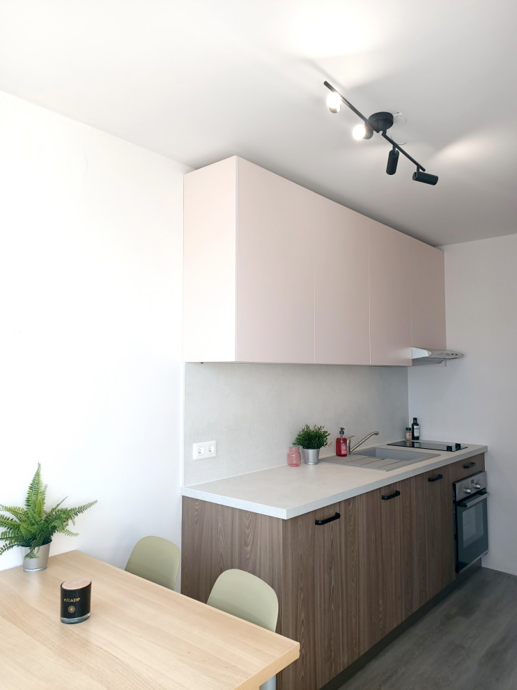 Aménagement de cuisine in bois brun With un évier 1 bac, un placard à porte plane, un plan de travail en béton, une crédence grise, un sol en bois brun, aucun îlot and un plan de travail gris.