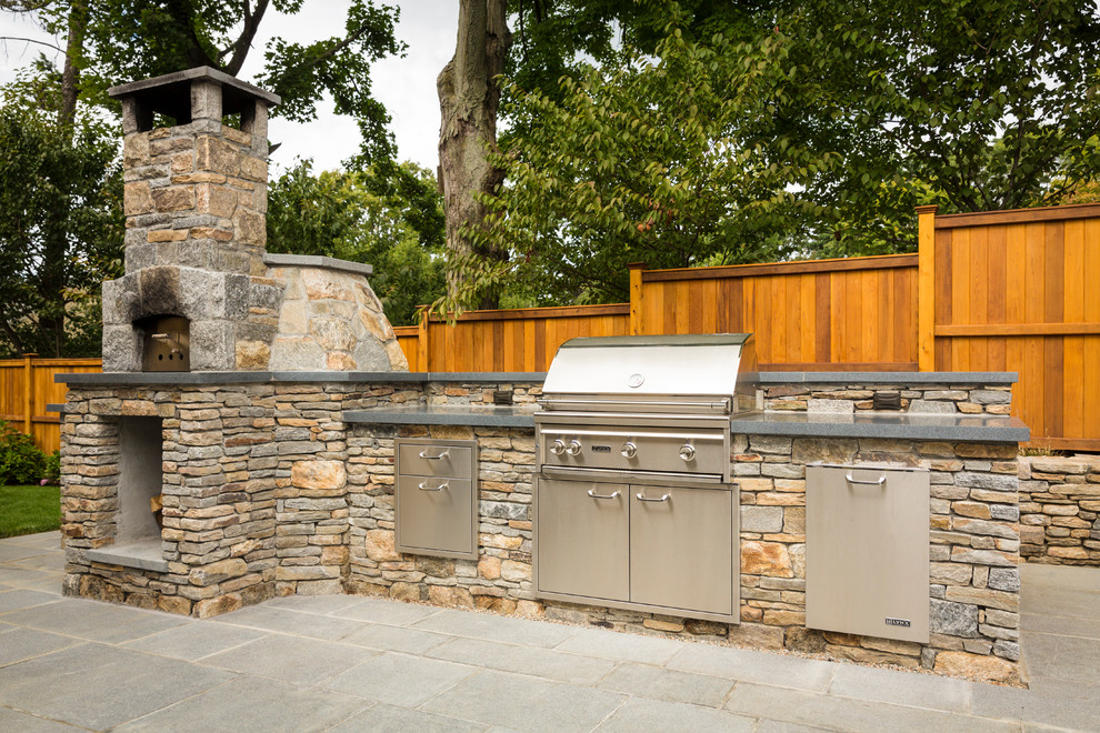 Small contemporary backyard patio in New York with an outdoor kitchen, no cover and natural stone pavers.